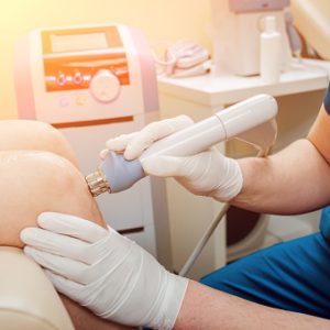 Shock wave therapy. The magnetic field, rehabilitation. Physiotherapist doctor performs surgery on a patient's knee
